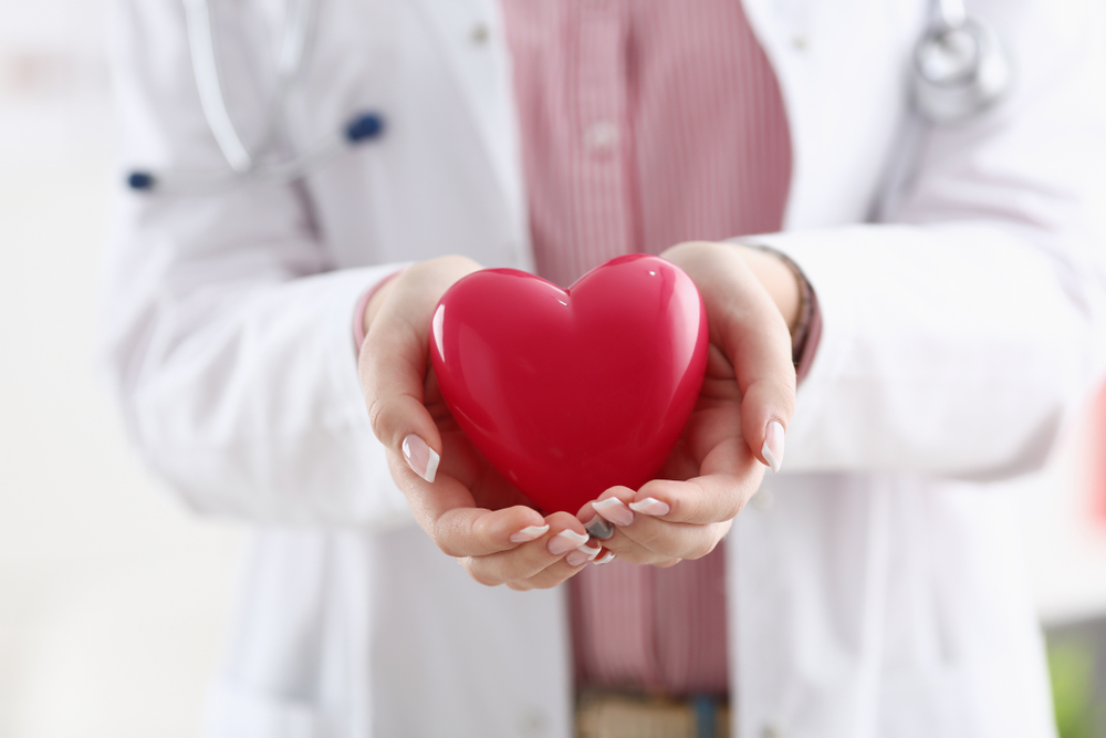 Female,Doctor,Hold,In,Arms,And,Cover,Red,Toy
